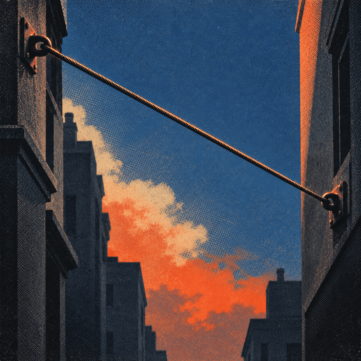 A steel cable strung between two buildings across a narrow street at dusk